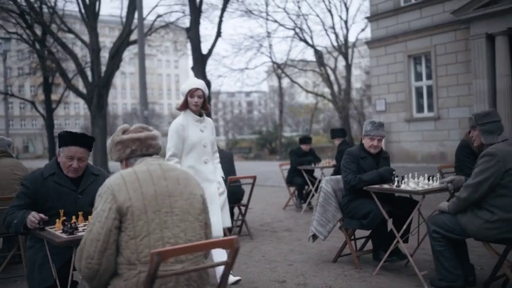 fille rousse avec manteau blanc se baladant parmi des joueurs d'&eacute;checs, en Russie, il fait froid dehors