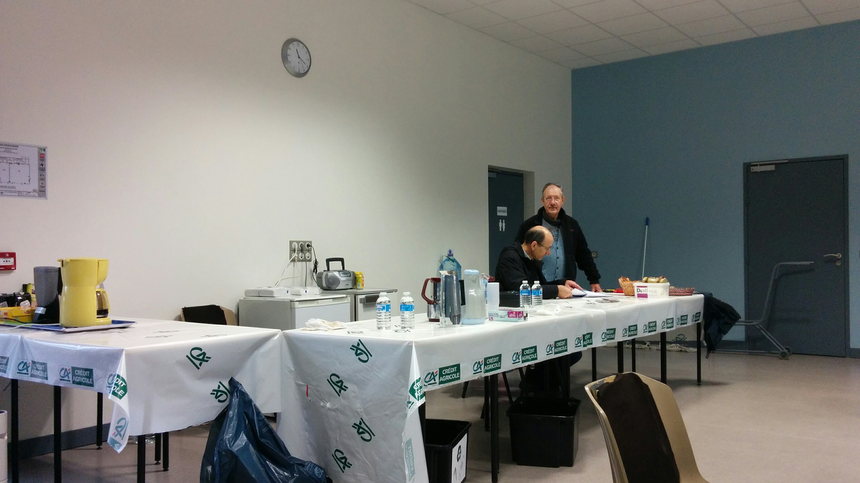 Eric et Joël à la buvette, sur une nappe aux couleurs du Crédit Agricole
